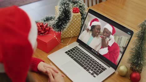 Glückliche-Kaukasische-Frau-Bei-Einem-Videoanruf-Mit-Einem-älteren-Paar-Zur-Weihnachtszeit