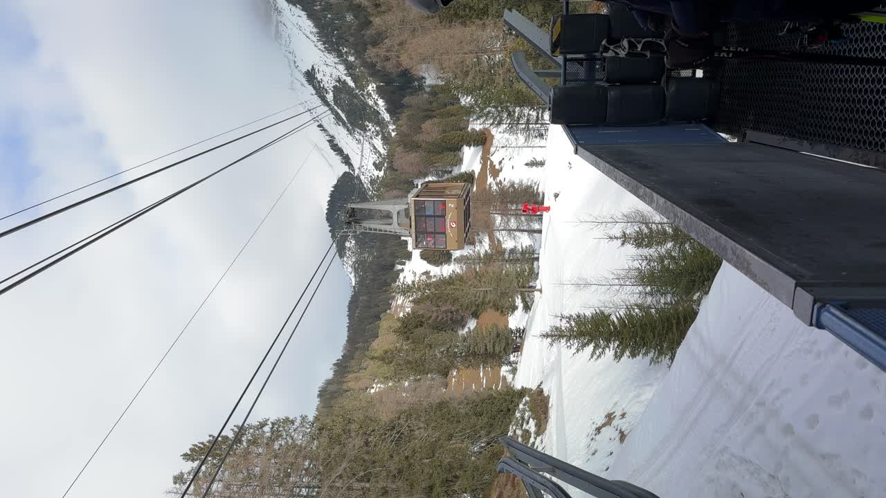 una impresionante filmación vertical de un teleférico que sube las montañas en invierno, mostrando las impresionantes vistas de los dolomitas de seceda en ortisei