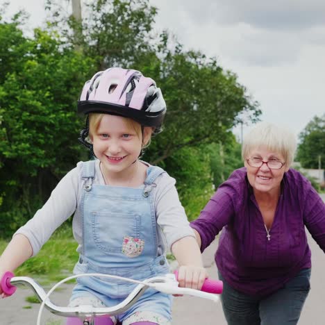 Großmutter-Bringt-Ihrer-Enkelin-Das-Fahrradfahren-Bei
