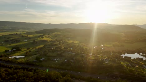 aerial establishing orbit above minnamurra, australia, capturing a sunrise over lush landscapes and coastal scenery