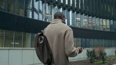 man walking in city with smartphone