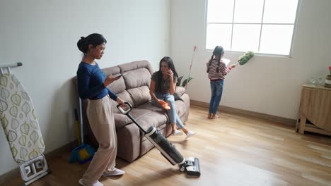 funny asian family using smartphone while doing housework