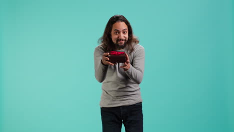 portrait of smiling man offering gift for birthday celebration