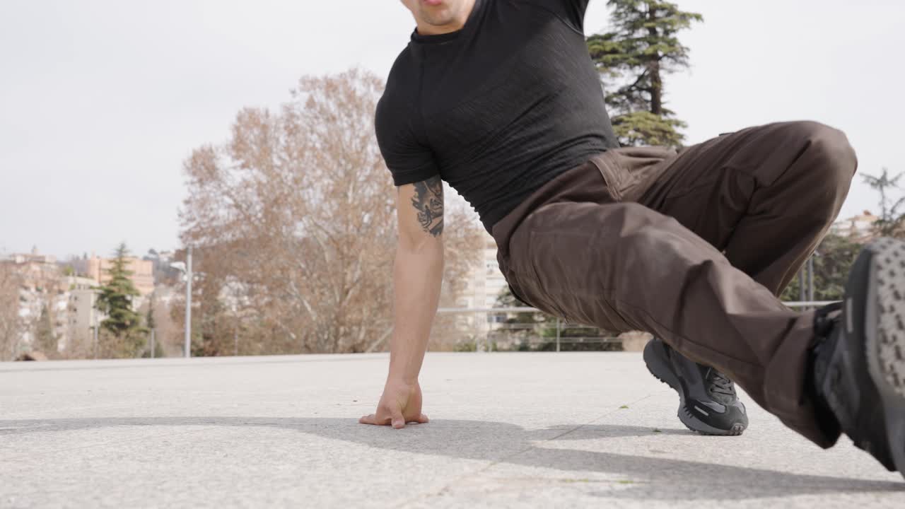 Breakdancer performing freeze moves in urban park