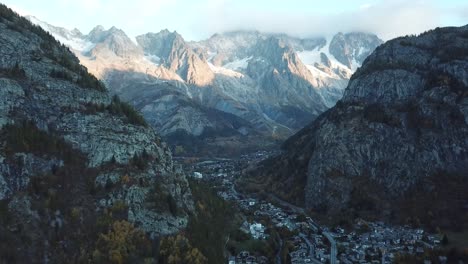 calm ascending aerial at iconic mont blanc from courmayeur, italy, aosta valley, italian alps in autumn with fall colors on forest and trees