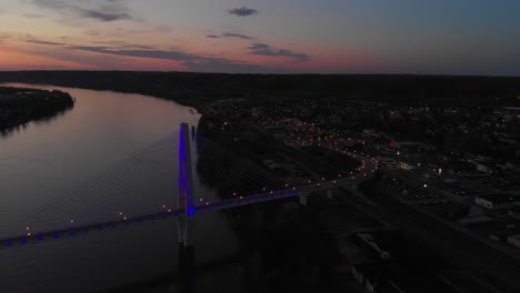 dusk parallax shot of light up glowing suspension bridge