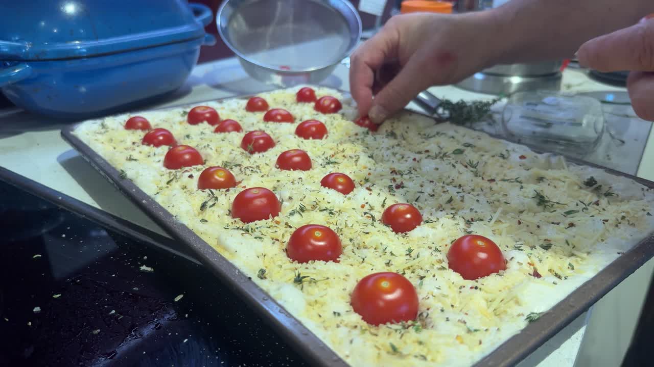 Pomodorini ciliegino disposti su focaccia non cotta
