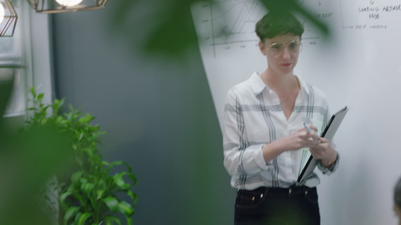 mujeres de negocios creativas diseñadores de lluvia de ideas trabajando juntos en un proyecto de diseño web mujer caucásica planificación estrategia de desarrollo utilizando investigación en línea escribir ideas en pizarra en la oficina moderna