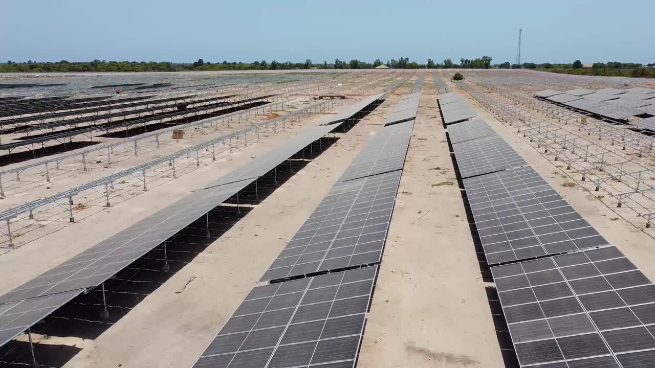 vista aérea deslizante a la izquierda sobre paneles solares bifaciales sucios y polvorientos en el sitio del proyecto de generación solar de jambur en construcción - gambia