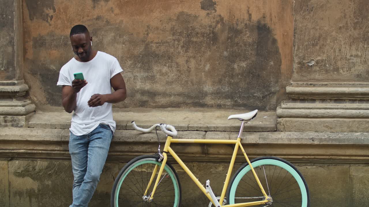 Uomo in bicicletta che usa il telefono all'aperto