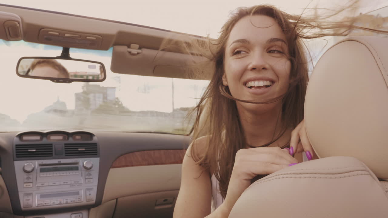 mujer feliz conduciendo en un coche descapotable