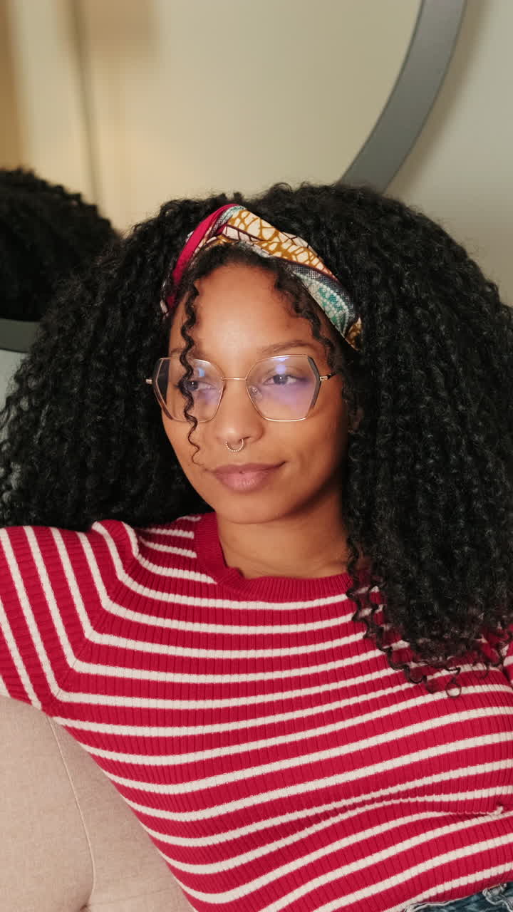Young Woman with Curly Hair and Glasses Blinking and Looking Around