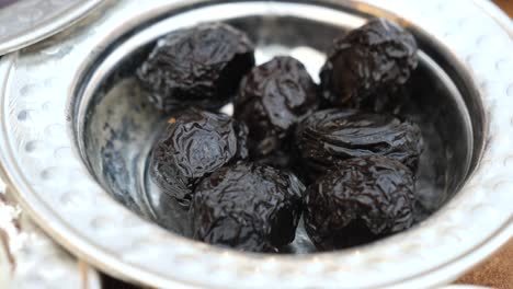 close up of black olives in a metal bowl