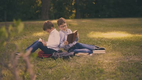 joyful-schoolmates-do-home-task-after-lessons-on-green-lawn