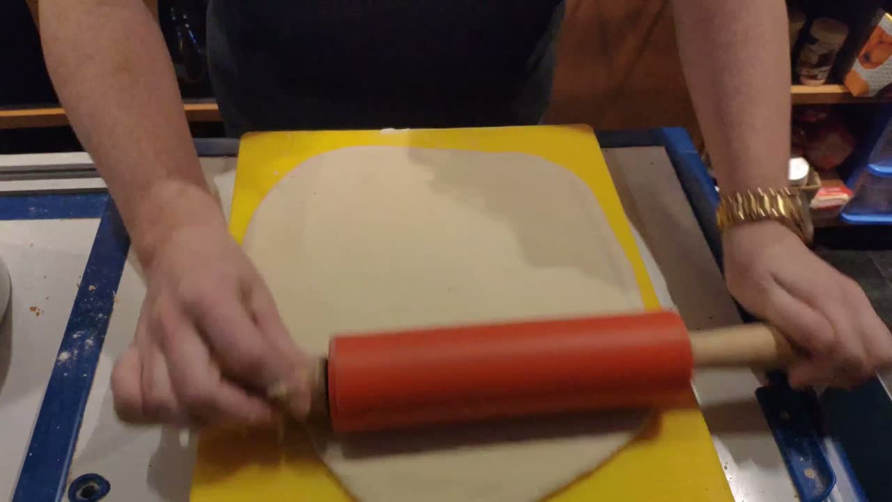 pastelera estirando masa de harina de trigo con su rodillo para preparar galletas orgánicas para vegetarianos en el horno, el área de trabajo de su negocio de catering, toma de foco, pedidos, galicia, españa