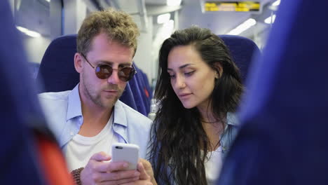 couple looking at phone on a train