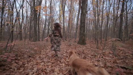 woman walking her dog along an autumn forrest path