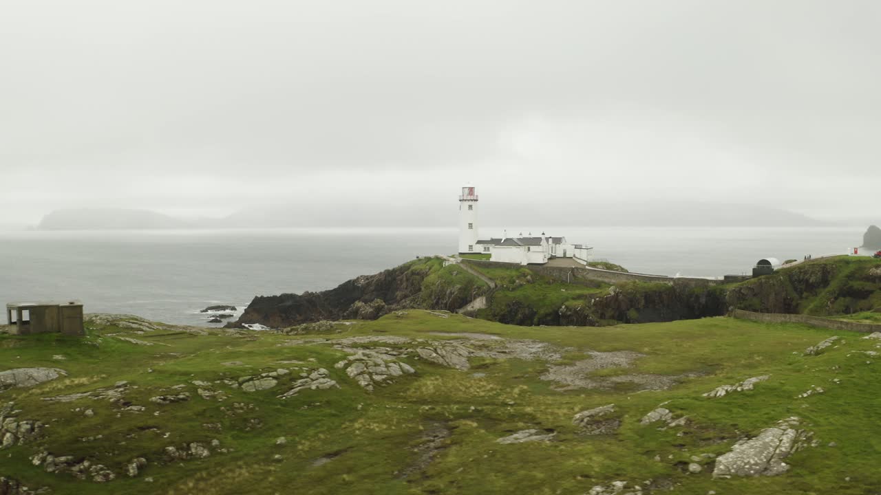 fotografía aérea que establece el faro solitario en fanad head, irlanda del norte