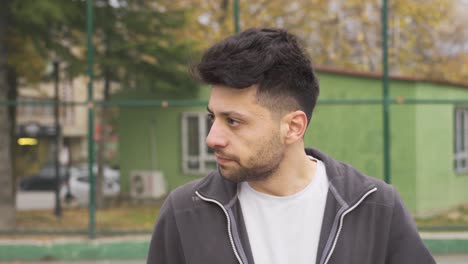 el joven al aire libre en la ciudad está confundido y enojado.