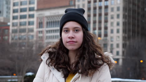 close up of a beautiful young latina woman smiles looking into the camera in an urban city environment outdoors