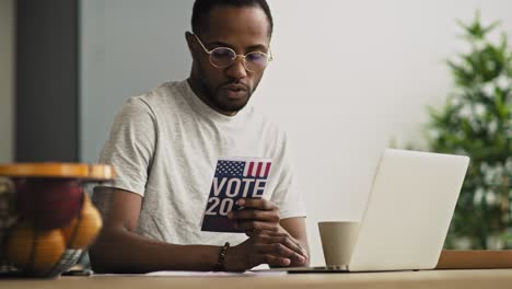 handheld video of focused black man holding vote leaflet.