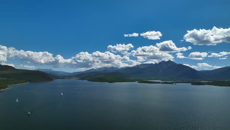 aerial cinematic drone breckenridge ski resort mountain wide motorboats sailing lake dillon colorado 9 mile range summer blue sky beautiful daytime frisco silverthorne reservoir forward pan up motion