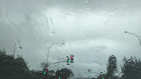 traffic lights seen through a wet windscreen during a grey rainy day