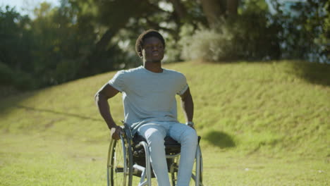 Vista-Frontal-Del-Hombre-Negro-En-Silla-De-Ruedas-Disfrutando-De-Un-Paseo-En-El-Parque