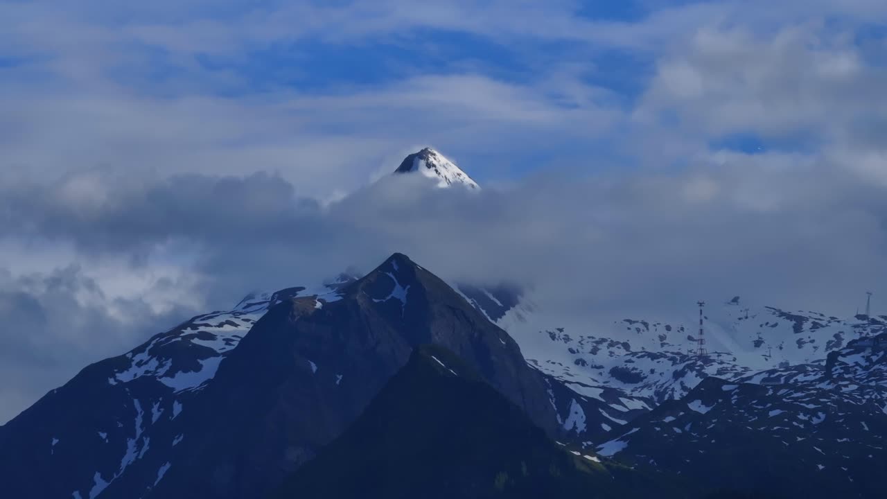 por encima de las nubes, la cima de una majestuosa montaña cubierta de nieve y hielo