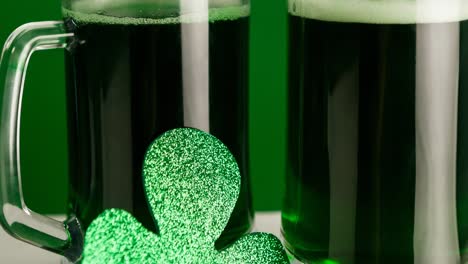animación de dos vasos de cerveza y hoja de trébol sobre un fondo verde