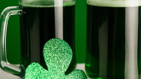 animation of two glasses of beer and clover leaf on green background