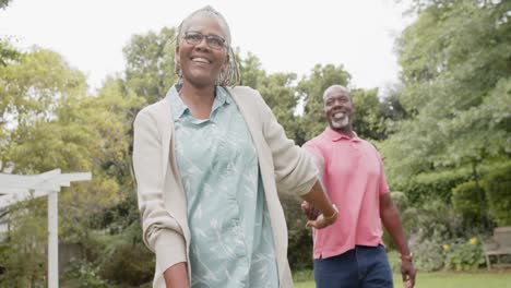 Feliz-Pareja-Afroamericana-De-Alto-Rango-Tomándose-De-La-Mano-Y-Caminando-En-El-Jardín,-Cámara-Lenta