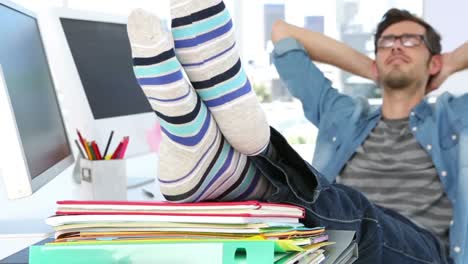 editor de fotos relajándose con los pies en su escritorio