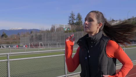 healthy young athletic woman out running in winter wearing jacket