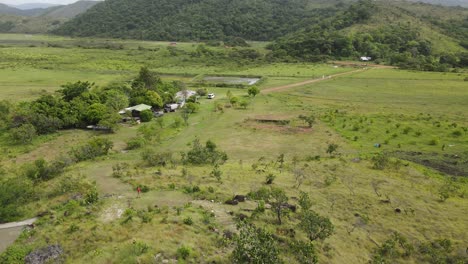 Aerial-View-of-Countryside-of-Guyana,-South-America,-Village-in-Valley,-Buildings-and-Green-Fields,-Drone-Shot
