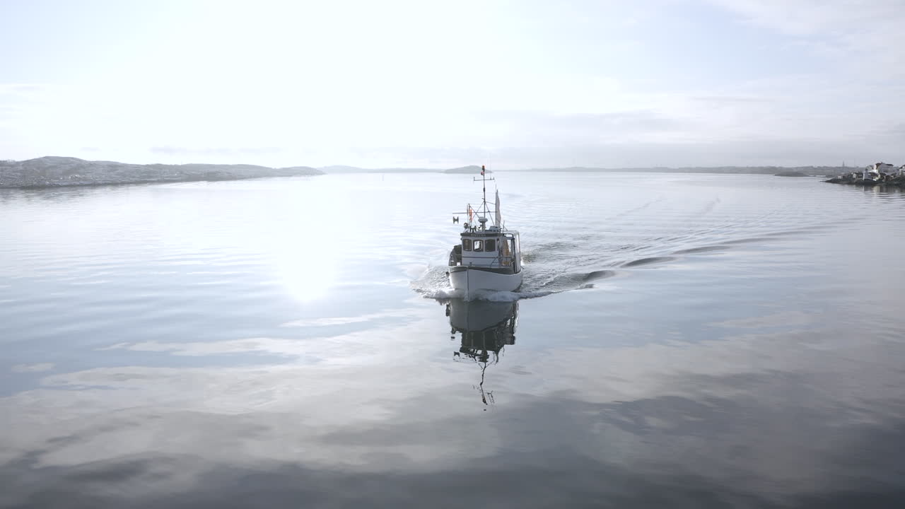 Drone shot of a professional fishing vessel boat returns to the port after fishing at Öckerö Island Municipality in Gothenburg archipelago, Sweden.