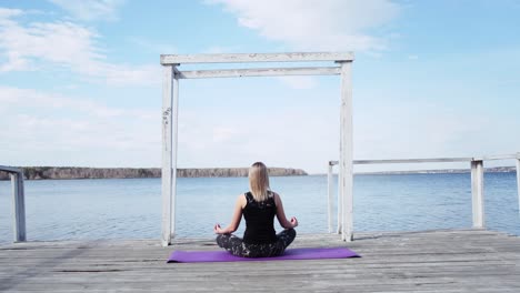 mujer meditando al aire libre junto al lago
