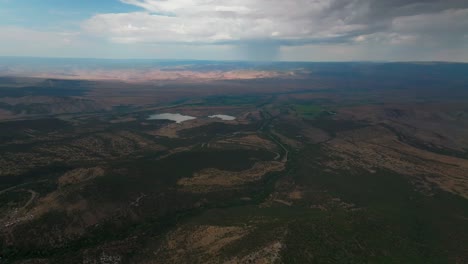 tierras de lluvia final colina subida grand mesa grand junction colorado avión no tripulado mañana de verano nubes tormenta lluvia soleadas laderas occidentales delta montrose olathe sombra pan oscuro movimiento a la izquierda