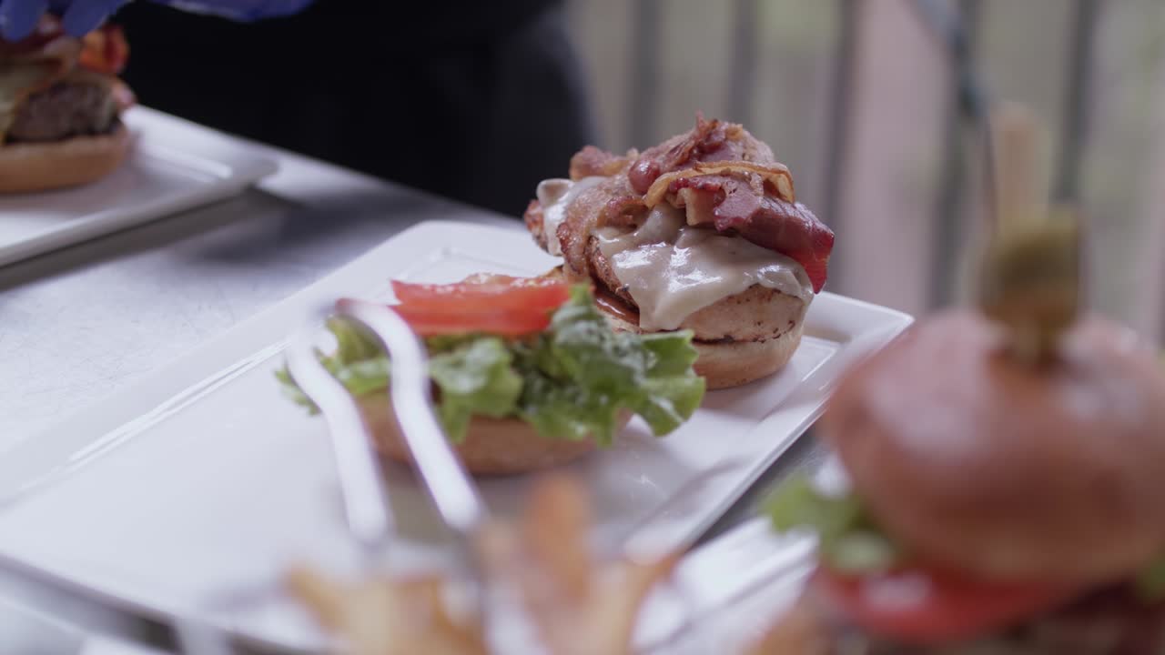 preparación de hamburguesas con tocino, tomates y lechuga por chef