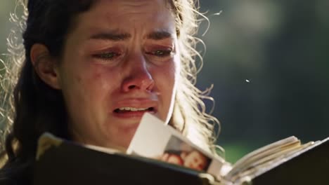 emotional journey of grief: a young woman's heartfelt connection to a book, tearfully revealing the depth of her inner turmoil and memories in nature's embrace