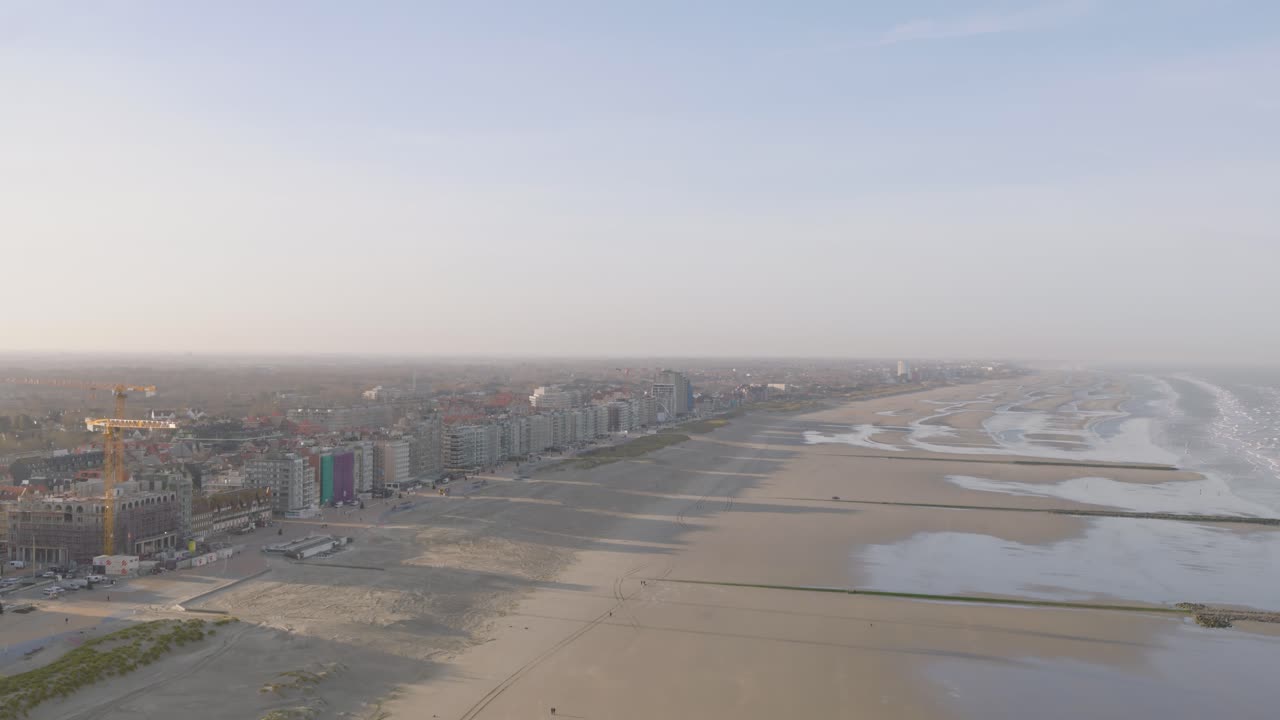 Vast sandy beach and Belgium township, aerial drone view