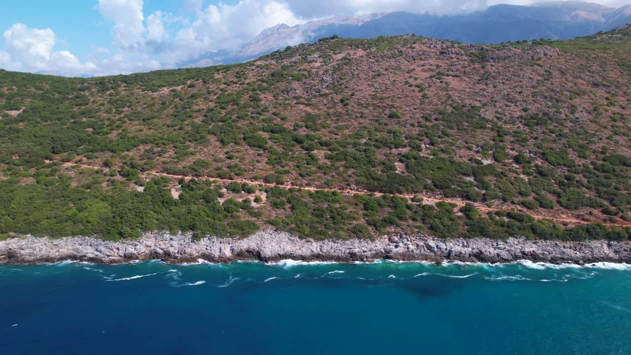 costa mediterránea en albania con costa rocosa y verdes colinas bañadas por agua de mar azul