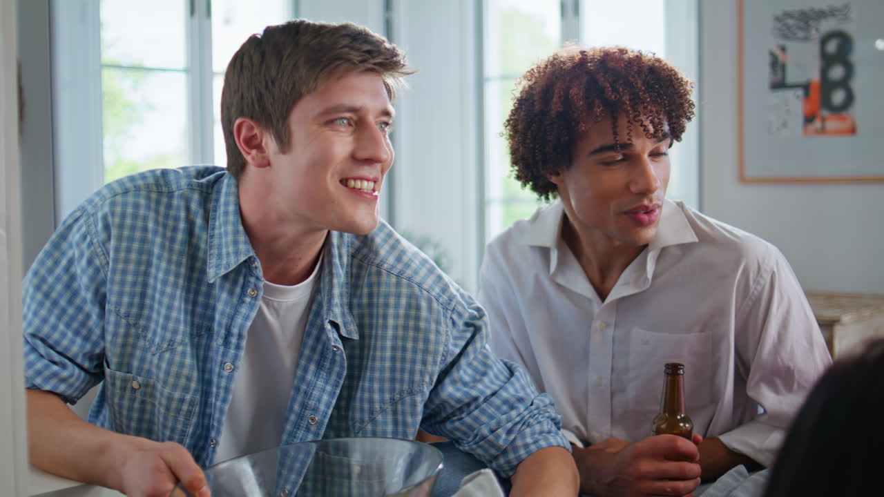 Two guys reacting emotionally supporting video gaming friends at home closeup