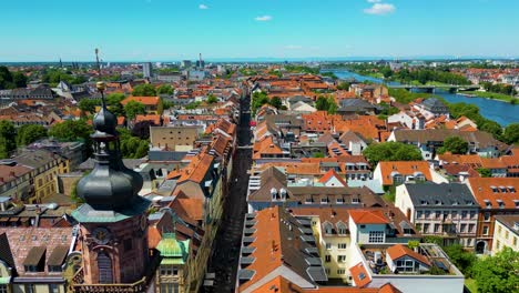 4k aerial drone video of historic homes, shops, and churches along the neckar river in downtown heidelberg, germany