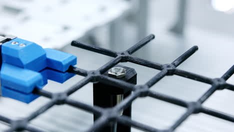 robotic arm interacting with a grid component in an automated manufacturing environment