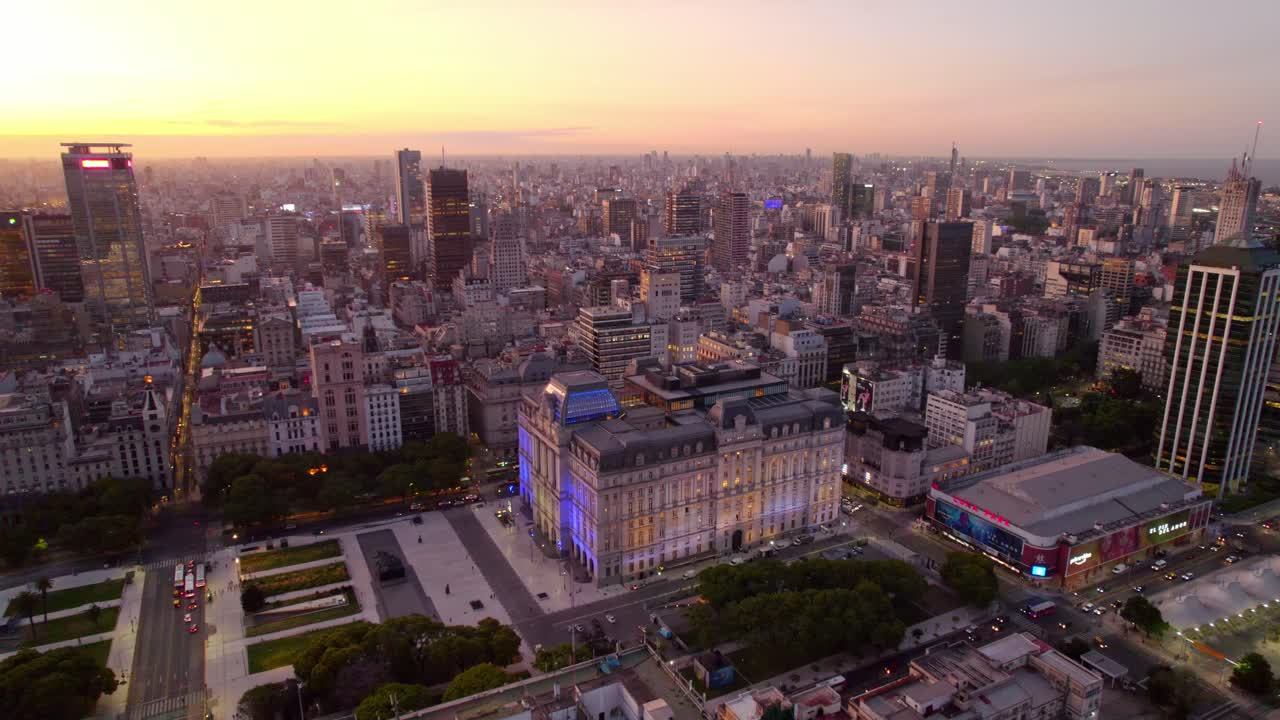 dolly en vista aérea del centro de buenos aires y el centro cultural kirchner iluminado en un atardecer épico, buenos aires, argentina