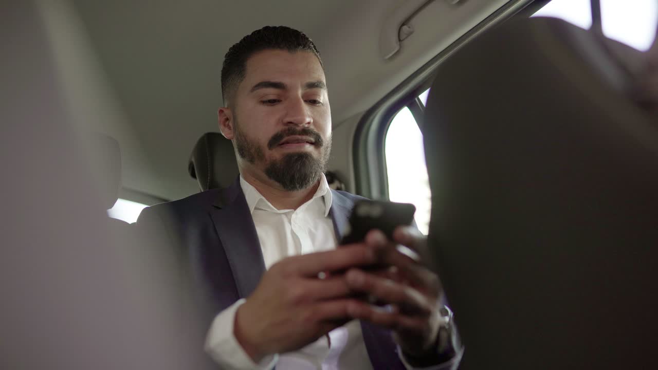 hombre de negocios sonriente usando teléfono celular en el coche