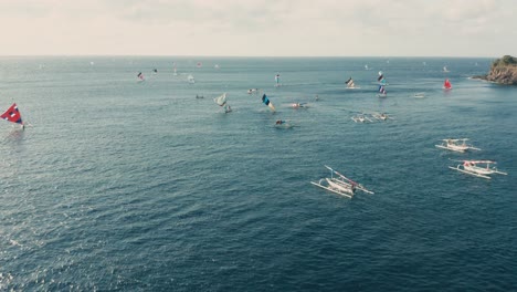 Balinese-fishing-boats-floating-around-in-blue-water,-aerial