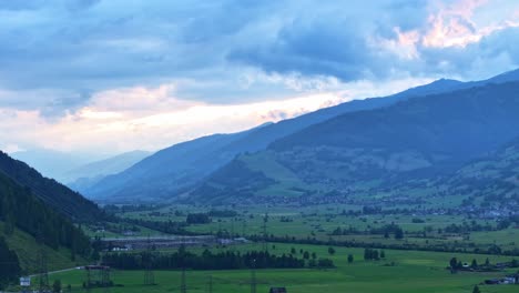 Clouds-moving-together-over-the-outline-of-mountain-range-and-valley-below,-hyperlapse