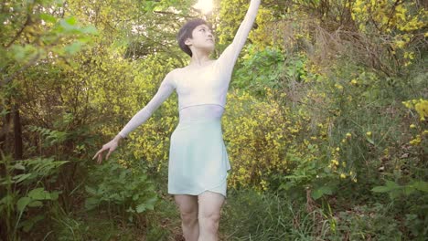 a japanese ballerina walks through flowers and the forest in this dream-like slow motion medium-wide clip